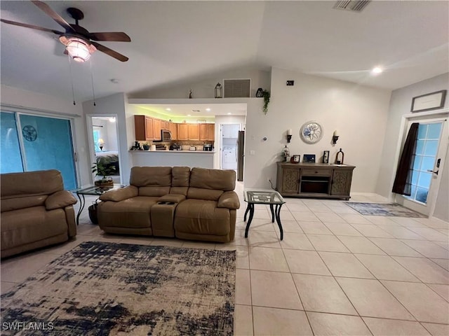 living room featuring ceiling fan, light tile patterned floors, and vaulted ceiling