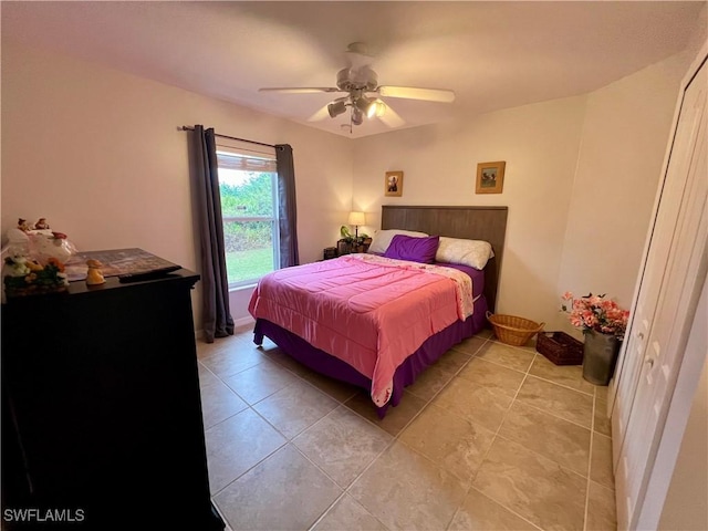 bedroom with ceiling fan, tile patterned flooring, and a closet