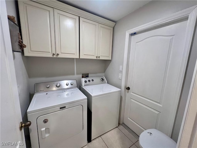 washroom featuring light tile patterned floors, washer and dryer, and cabinets