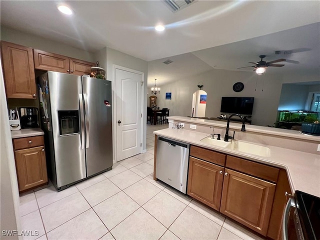 kitchen featuring sink, appliances with stainless steel finishes, light tile patterned flooring, and ceiling fan with notable chandelier