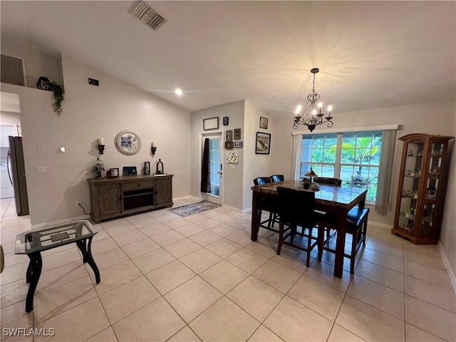 tiled dining space featuring lofted ceiling and a notable chandelier