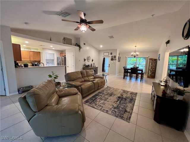 living room with high vaulted ceiling, light tile patterned floors, sink, and ceiling fan with notable chandelier