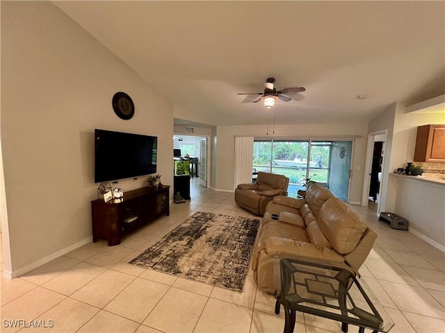 living room featuring ceiling fan, light tile patterned floors, and vaulted ceiling