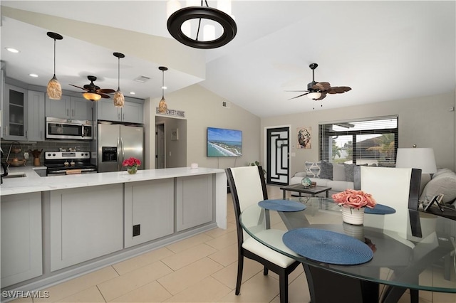 dining space with ceiling fan, sink, and lofted ceiling