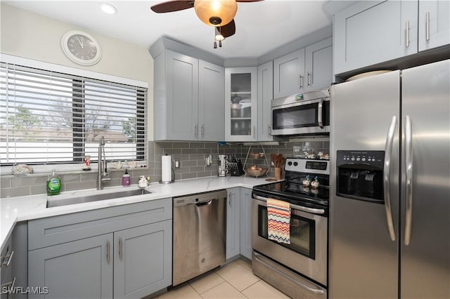 kitchen with sink, backsplash, gray cabinetry, and stainless steel appliances