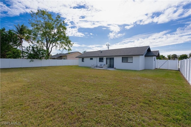 rear view of property featuring a yard and a patio