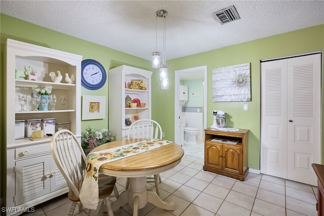 tiled dining area featuring a textured ceiling