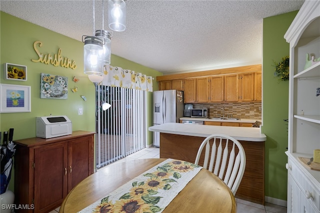 kitchen featuring appliances with stainless steel finishes, backsplash, decorative light fixtures, light tile patterned flooring, and sink