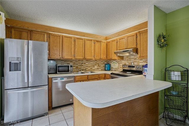 kitchen with stainless steel appliances, tasteful backsplash, sink, kitchen peninsula, and light tile patterned flooring