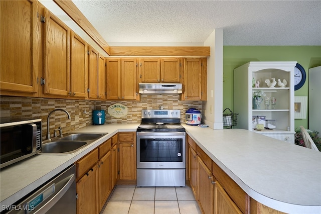 kitchen featuring backsplash, kitchen peninsula, sink, appliances with stainless steel finishes, and light tile patterned floors