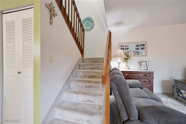 stairs featuring carpet floors and a textured ceiling