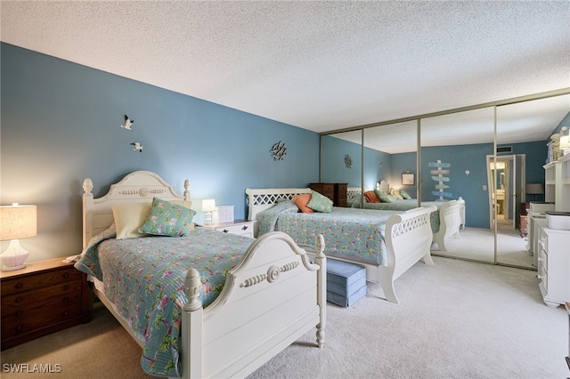 bedroom featuring a textured ceiling, a closet, and light carpet