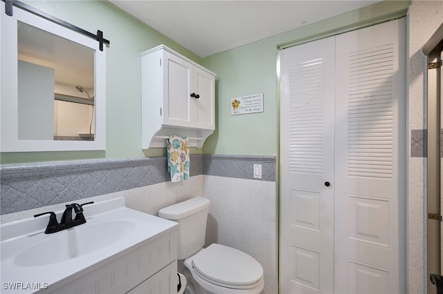 bathroom with tile walls, toilet, and vanity