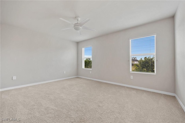 spare room featuring light colored carpet and ceiling fan