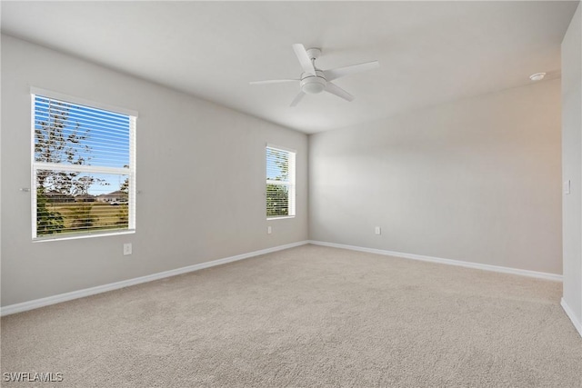 spare room featuring light colored carpet and ceiling fan