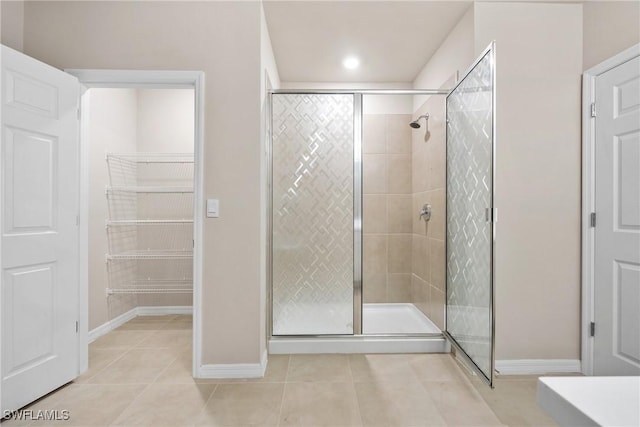 bathroom with tile patterned floors and a shower with door