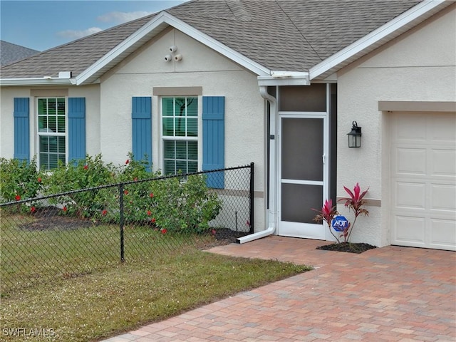 doorway to property featuring a garage and a yard