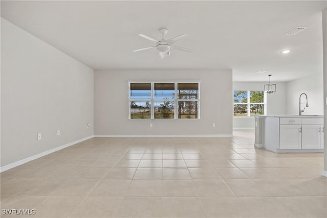 spare room featuring sink, ceiling fan with notable chandelier, and light tile patterned floors