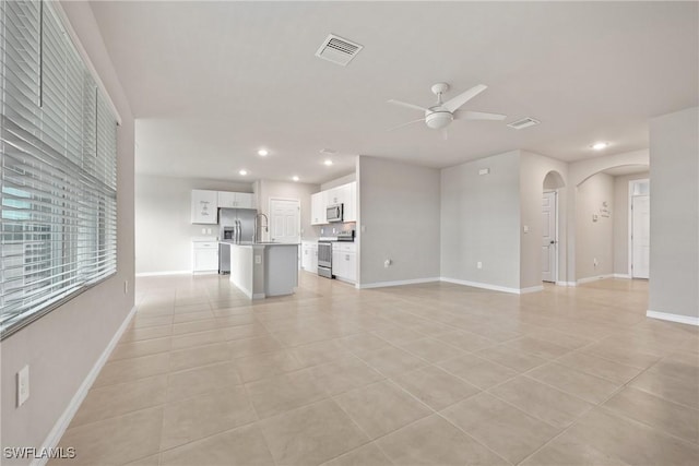 unfurnished living room with sink, ceiling fan, and light tile patterned flooring