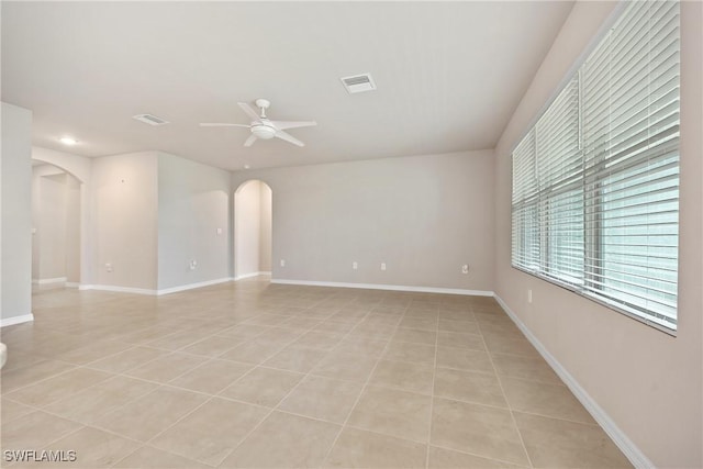 tiled spare room with ceiling fan