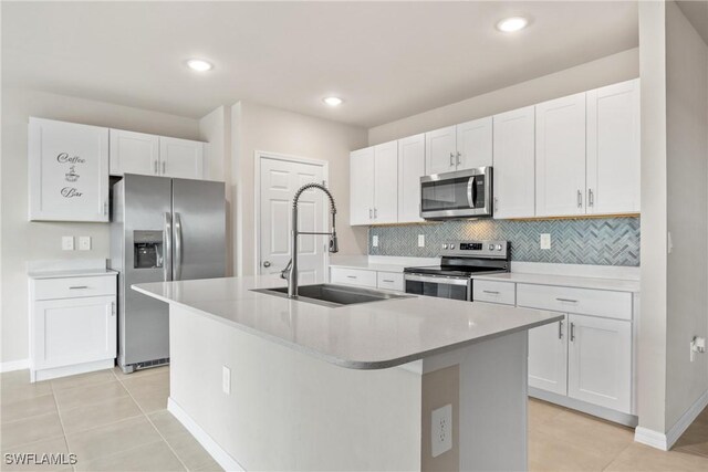 kitchen featuring sink, white cabinetry, light tile patterned floors, a center island with sink, and stainless steel appliances