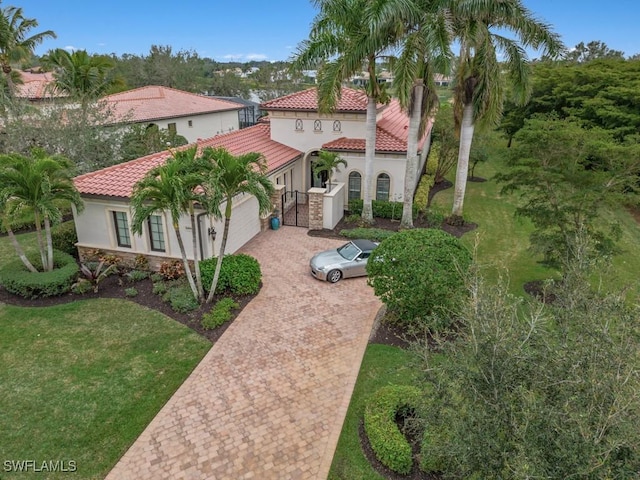 mediterranean / spanish home with a garage and a front yard