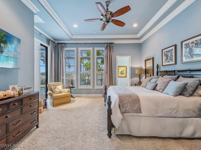 bedroom with ornamental molding, light carpet, ceiling fan, and a tray ceiling