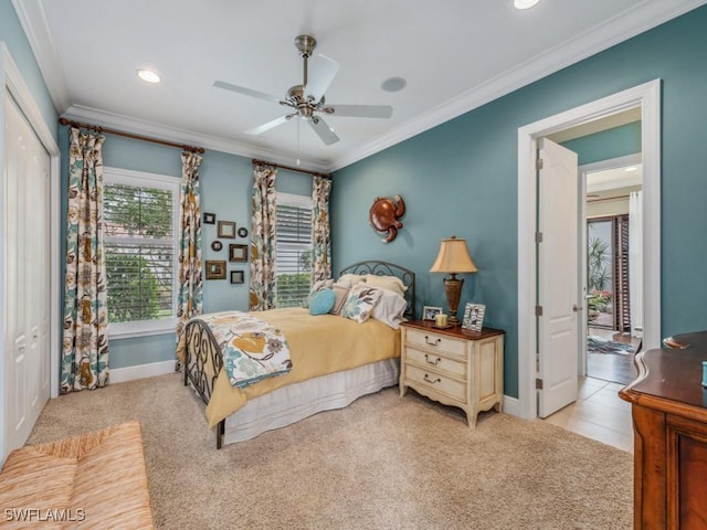 bedroom featuring ceiling fan, light colored carpet, ornamental molding, and a closet