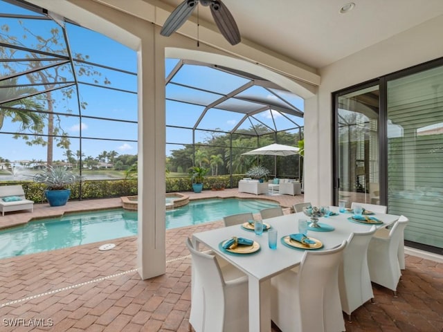 view of pool with an in ground hot tub, ceiling fan, glass enclosure, and a patio