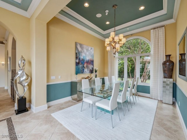 dining area with an inviting chandelier, light tile patterned floors, crown molding, and a raised ceiling