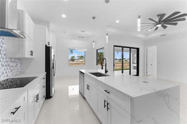 kitchen featuring white cabinets, wall chimney exhaust hood, sink, and stainless steel appliances