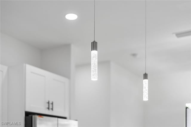 details with pendant lighting, refrigerator, and white cabinets