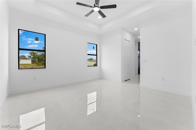 unfurnished room featuring ceiling fan and a tray ceiling