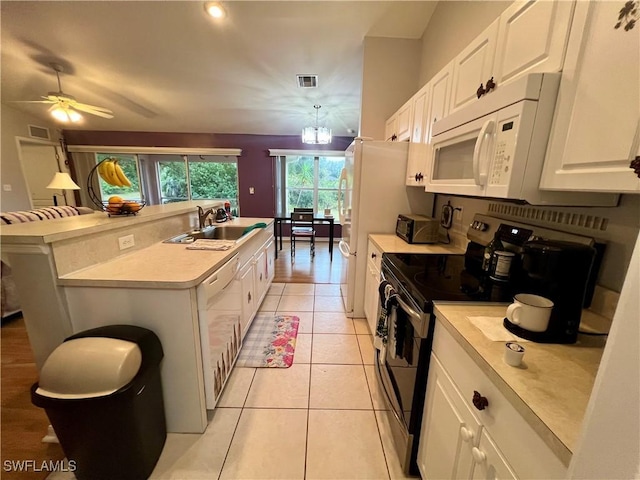 kitchen with white appliances, white cabinetry, sink, a kitchen island with sink, and light tile patterned floors