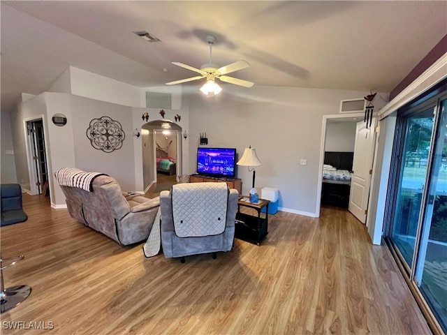 living room featuring ceiling fan, vaulted ceiling, and light hardwood / wood-style flooring