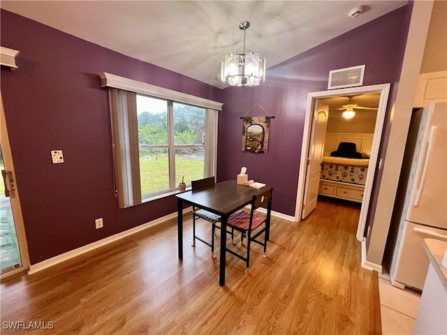 dining room with an inviting chandelier and light hardwood / wood-style flooring