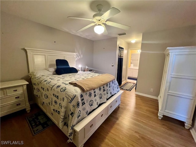 bedroom featuring ceiling fan, ensuite bath, and hardwood / wood-style floors