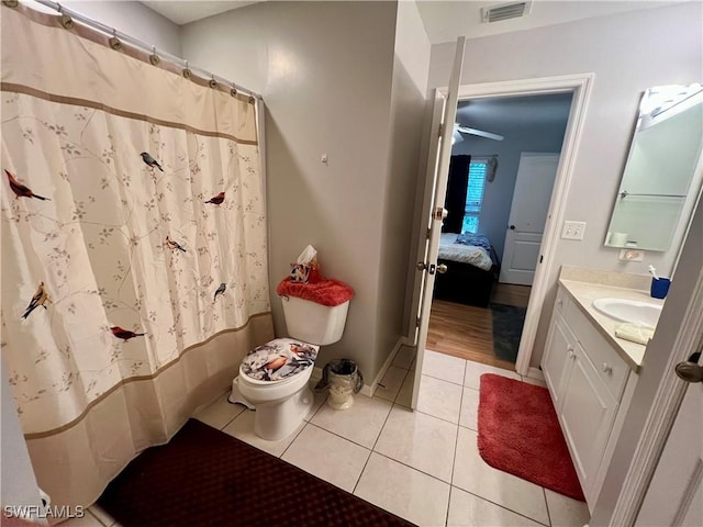 bathroom with toilet, tile patterned flooring, walk in shower, and vanity