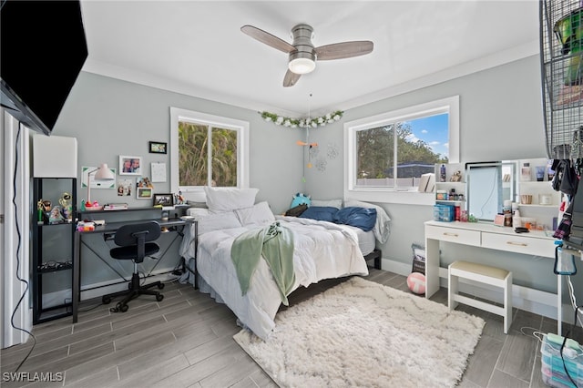 bedroom featuring ceiling fan, multiple windows, and crown molding