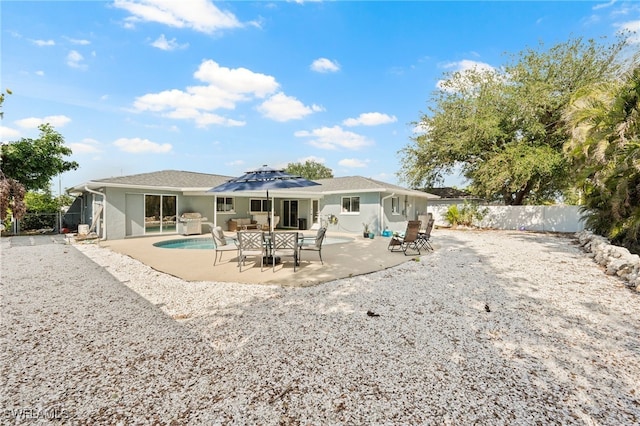 rear view of property featuring a fenced in pool, solar panels, and a patio