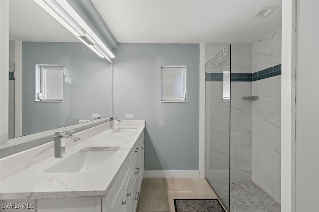 bathroom with tiled shower and vanity