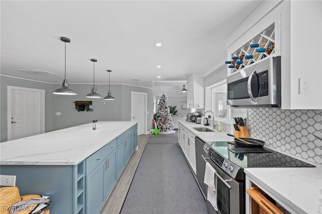 kitchen featuring decorative light fixtures, sink, tasteful backsplash, blue cabinets, and stainless steel appliances