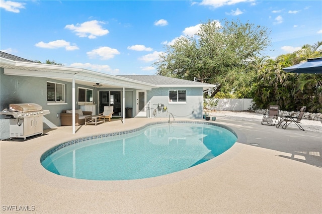 view of pool with ceiling fan, a patio area, and grilling area