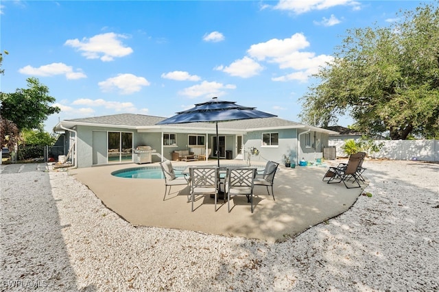 back of property with a fenced in pool and a patio area