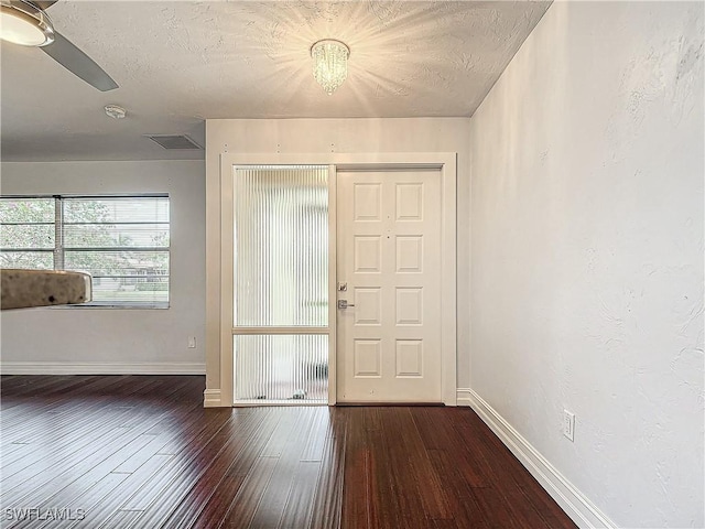 foyer featuring ceiling fan, dark hardwood / wood-style floors, and a textured ceiling