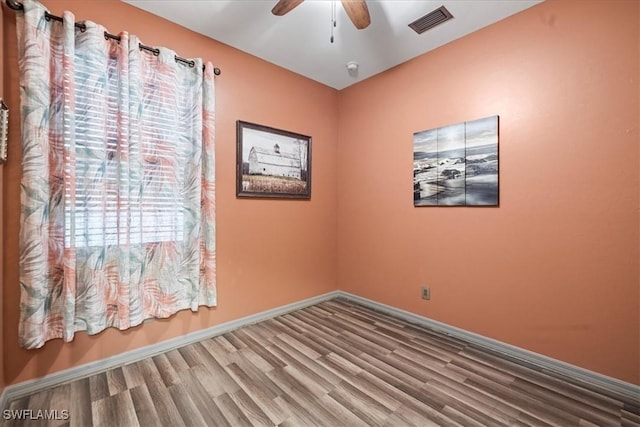 spare room with hardwood / wood-style flooring and ceiling fan