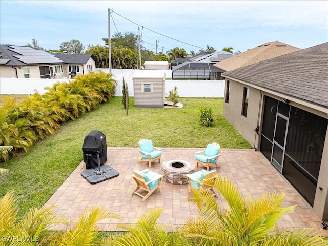 view of patio / terrace with a shed, an outdoor fire pit, and a grill