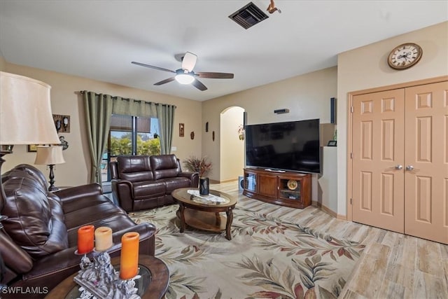 living room featuring light hardwood / wood-style flooring and ceiling fan