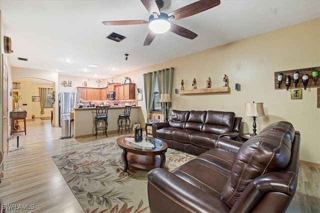 living room featuring light wood-type flooring and ceiling fan