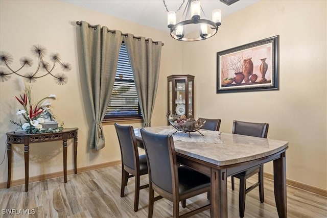 dining area featuring a chandelier and light wood-type flooring